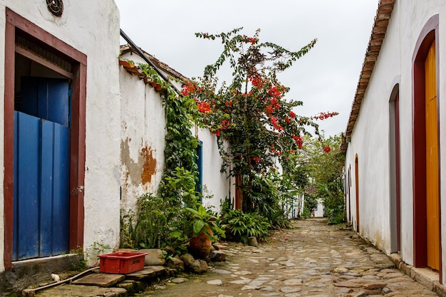 Old town street with flowers on the walls.