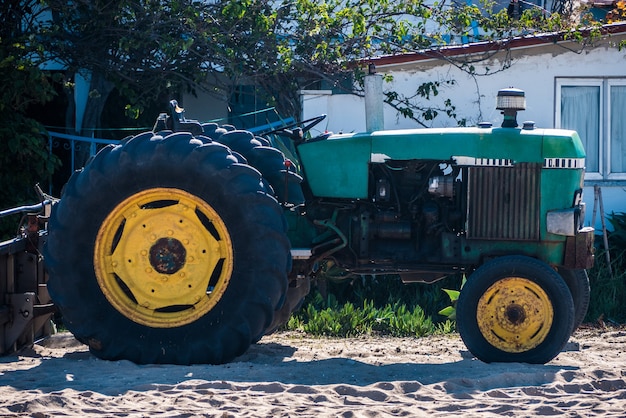 Старый трактор, стоящий на пляже.