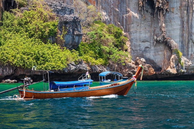 Old traditional Thai motorboat made of wood for fishing and tourists on excursions in the Andaman Sea near Phi Phi Leh island in clear turquoise water under a blue sky Travel and vacation in phuket