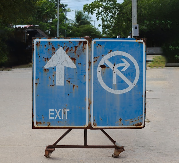 An old traffic sign tells an exit and a right turn is prohibited