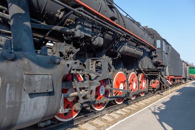 Ruote d'annata rosse del vecchio treno sulla ferrovia.