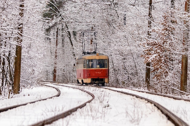 Старый трамвай едет по зимнему лесу
