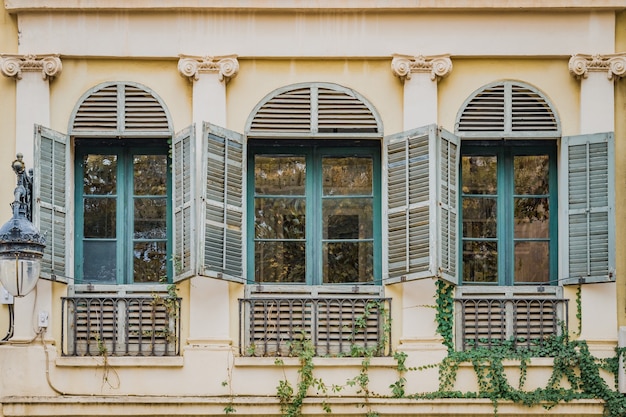 Old turquoise windows of a neoclassical style residential house