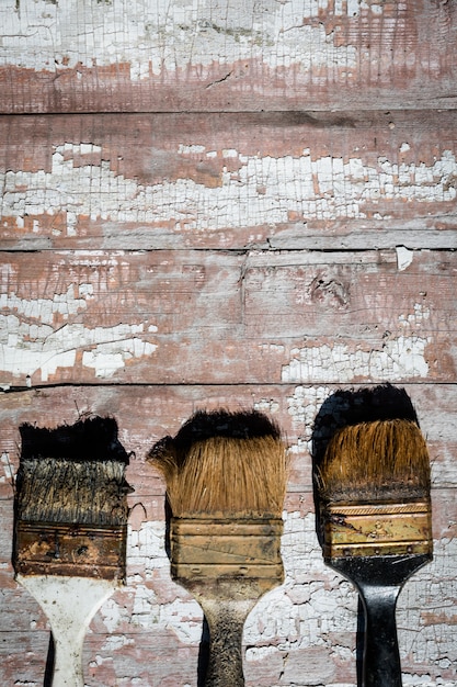Old used brushes against the background of an old dried paint