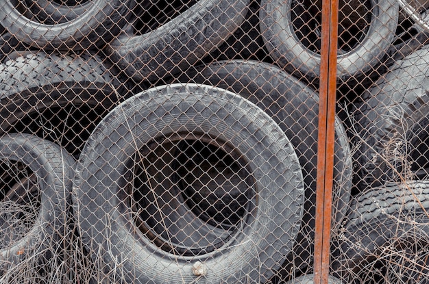 Old used damaged car tires at the dump