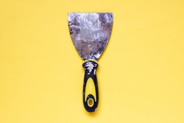 old used dirty filling putty knife with traces of plaster