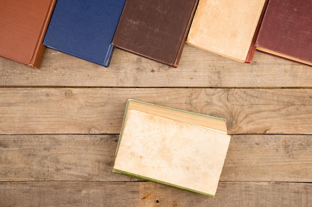 Old and used hardback books or text books on wooden table