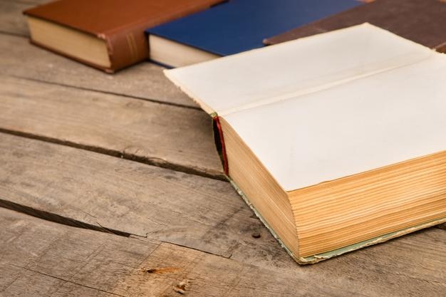 Old and used hardback books or text books on wooden table