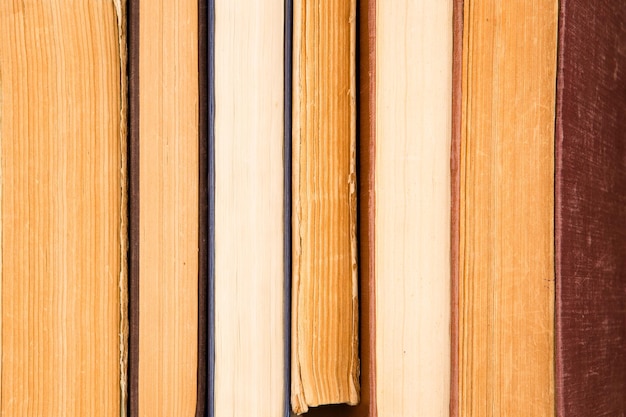 Old and used hardback books or text books on wooden table