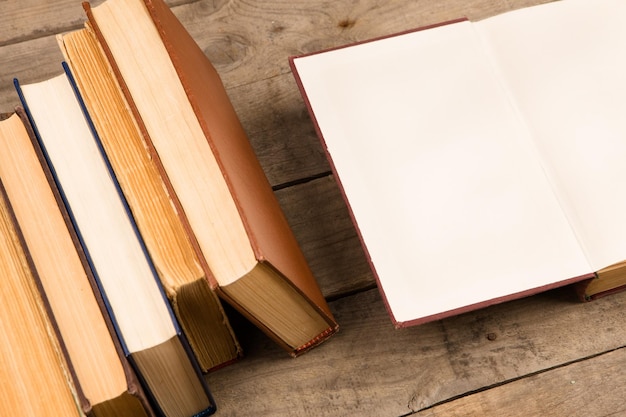 Old and used hardback books or text books on wooden table