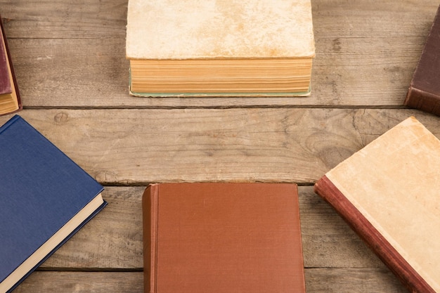 Photo old and used hardback books or text books on wooden table