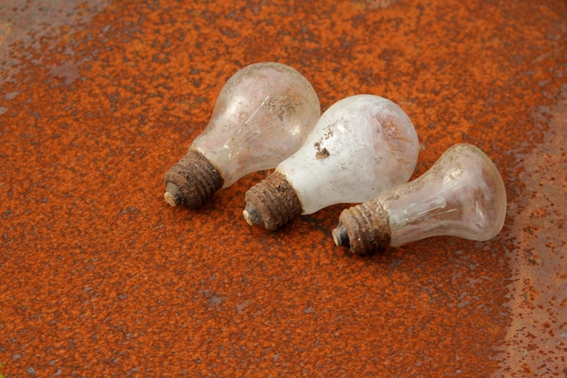 Old used light bulbs on a rusty metal surface