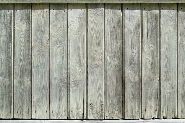 Old vertical wooden planks close up gray white wall of planks sunny day place for text copy space