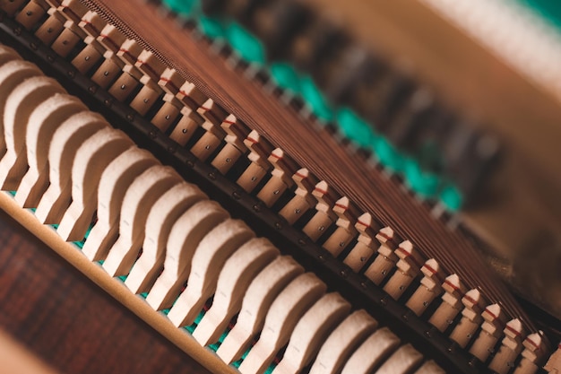 Old vintage acoustic piano inside with hammers and strings close up Tuning musical instrument Selective focus