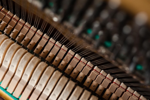 Foto vecchio pianoforte acustico vintage all'interno con martelli e archi da vicino messa a fuoco selettiva dello strumento musicale