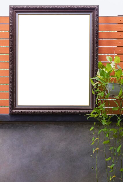 The old vintage blank picture frame on wooden plank and loft cement wall with clipping path