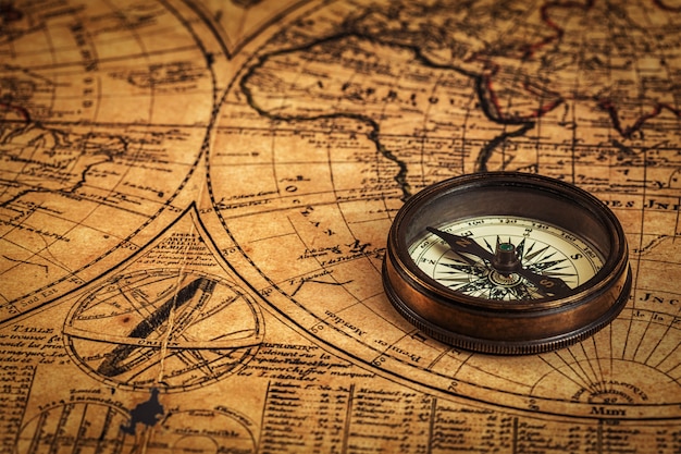 Old vintage compass on ancient map