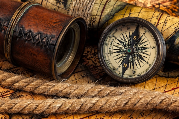 Old vintage compass and navigation instruments on ancient map