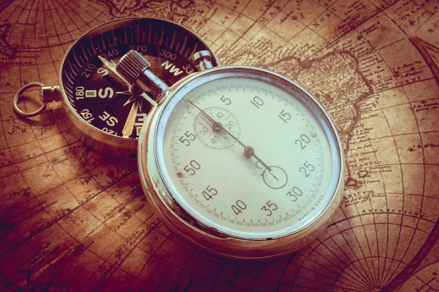 Old vintage compass and travel instruments on ancient map