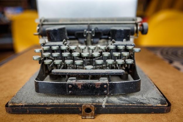 Old vintage dustcovered typewriter with sheet of white paper