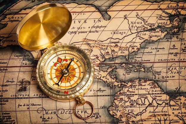 Old vintage golden compass on ancient map