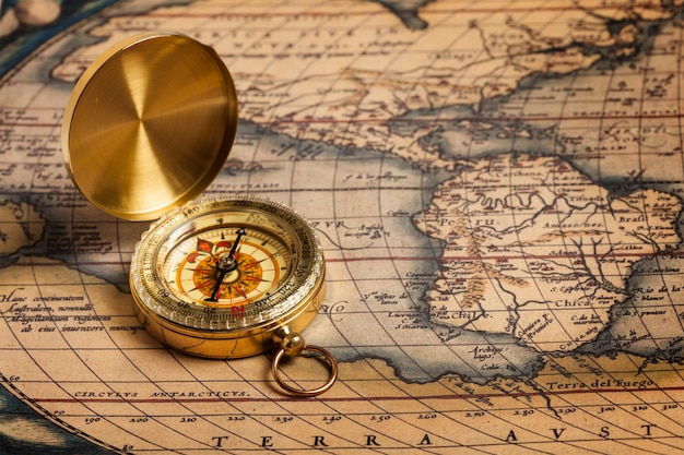 Old vintage golden compass on ancient map