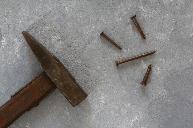 Old vintage hammer and nails on a wooden background closeup selective focus