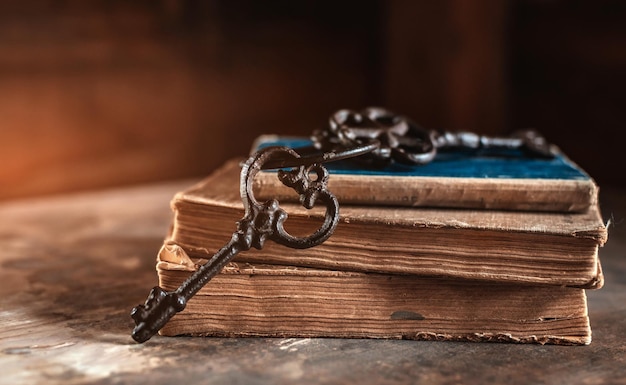 Old vintage keys on an old battered book wooden background