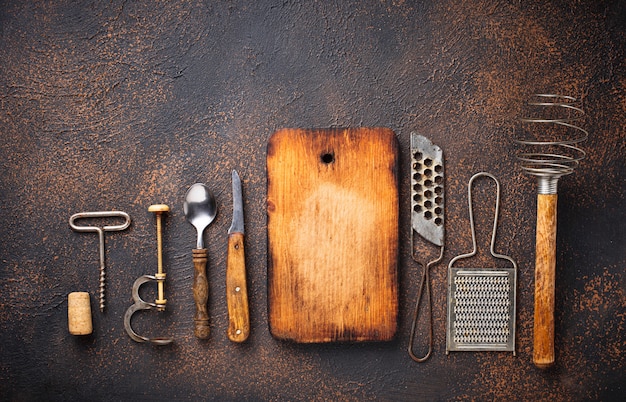 Old vintage kitchen utensils on rusty background