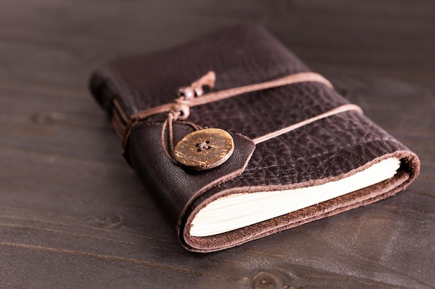 Old vintage notebook with leather cover on wooden backgorund