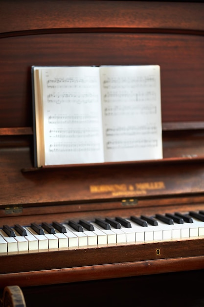 Foto vecchio pianoforte vintage con note musicali a un festival di musica classica un'antica tastiera in legno con un libro di composizione pronto per la creazione di una melodia in una galleria d'arte uno strumento musicale classico