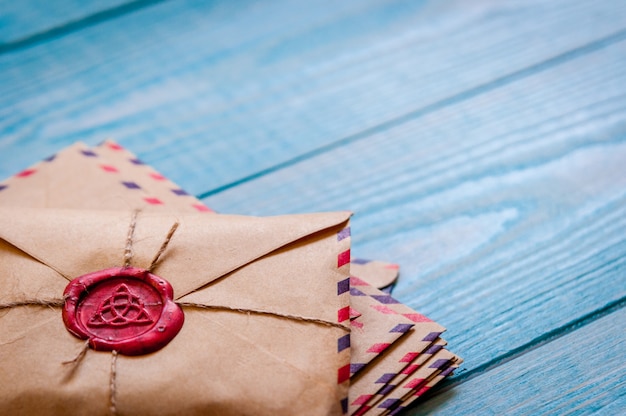 Old vintage retro envelopes with a wax stamp on old blue wooden table