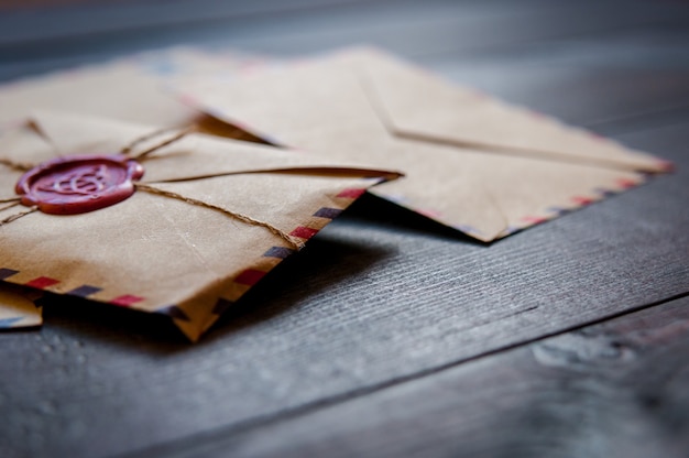 Old vintage retro envelopes with a wax stamp on old dark brown wooden table