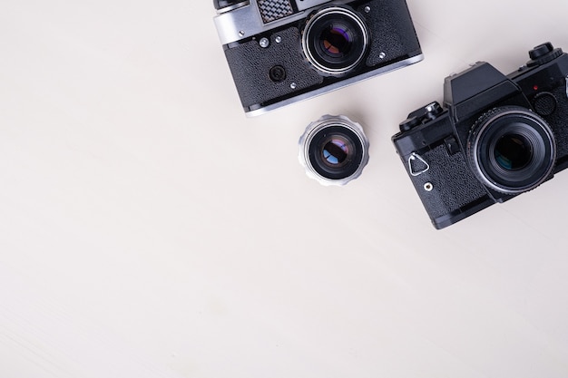 Old vintage retro photo film rangefinder camera and SLR camera with lens, copyspace top view  background