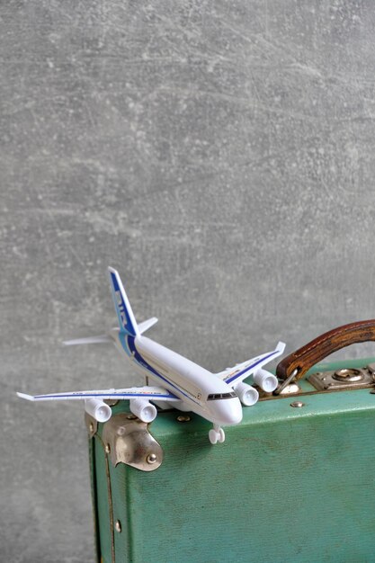 Old vintage retro suitcase and toy airplaneConcept vacation and travel