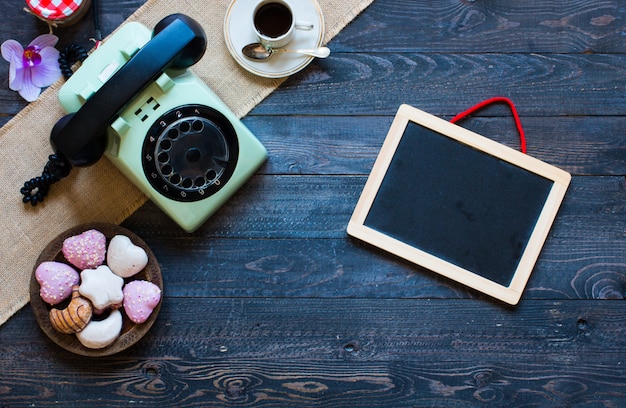 Old vintage telephone with biscotti coffee donuts on a wooden background