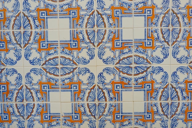 Old vintage tiles of blue and orange geometrical ornate on the wall downtown Lisbon Portugal