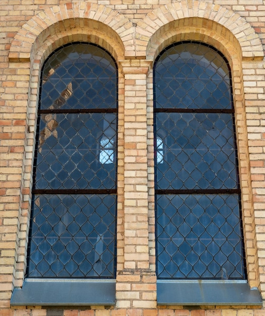 Old vintage window on a brick building Arched windows on the church