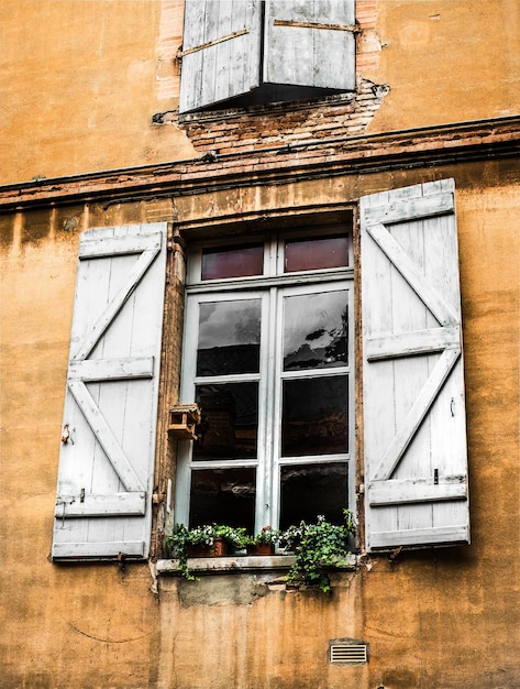 old vintage window and opened wooden shutters traditional European windows