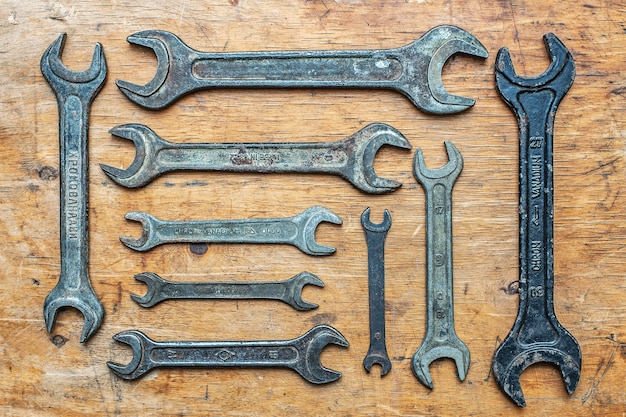 Photo old vintage wrenches on wooden background. top view.