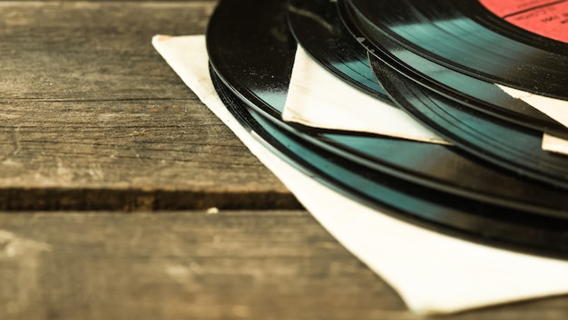 Old vinyl record on the wooden table, selective focus and toned image