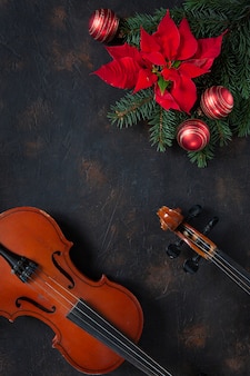 Vecchi rami di violino e abete con decorazioni natalizie e poinsettia