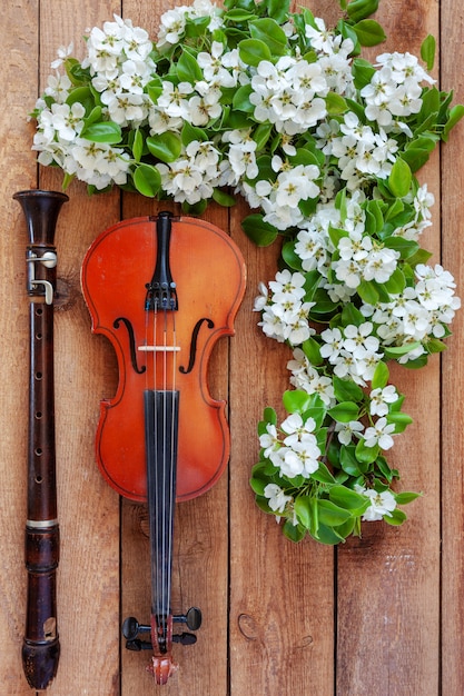 Old violin, flute and blossoming apple tree branches.