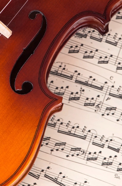 Old violin lying on the sheet of music, music concept