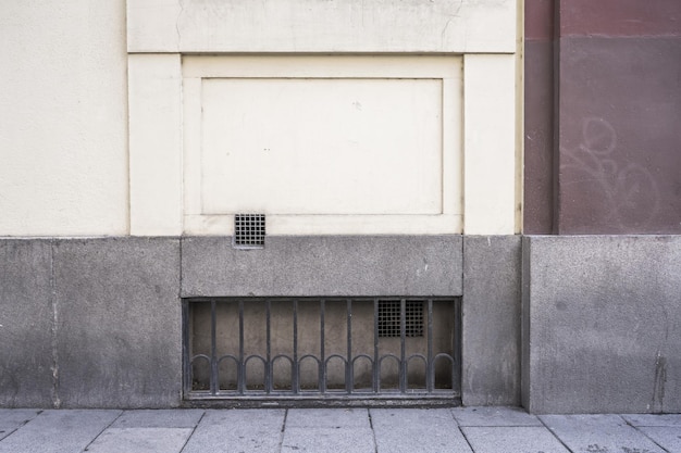 An old wall of a building with granite blocks and a ventilation hole in the lower part