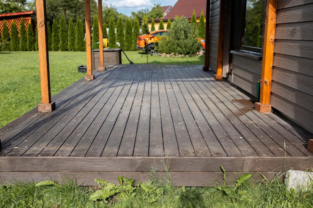 Old weathered wooden deck and new facade of a modern house