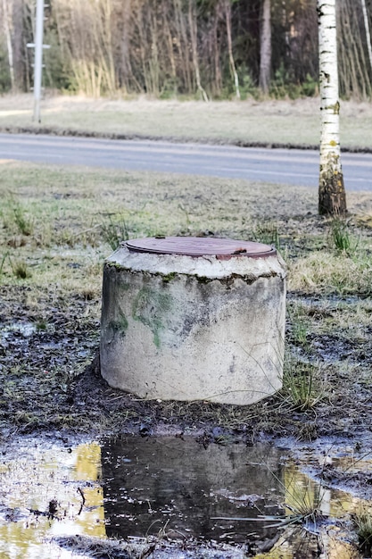 Old well in a puddle by the road