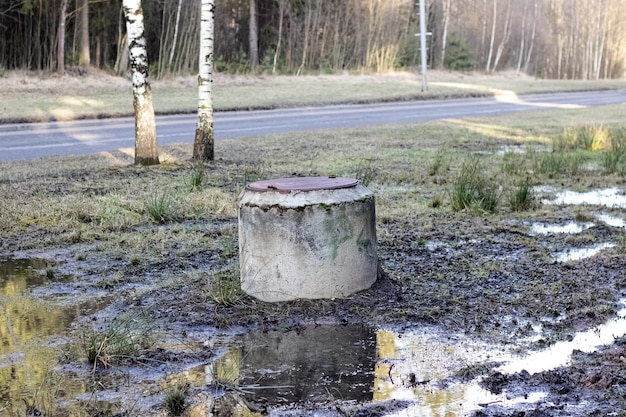 Old well in a puddle by the road