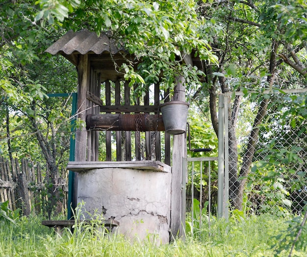 写真 きれいな飲料水の写真撮影用の長い鍛造チェーンに鉄のバケツが付いた古い井戸