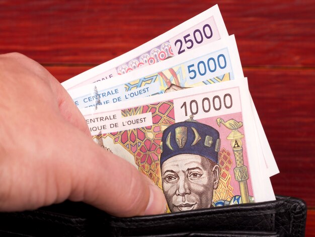 Деньги франк из старых западноафриканских государств в черном кошельке
